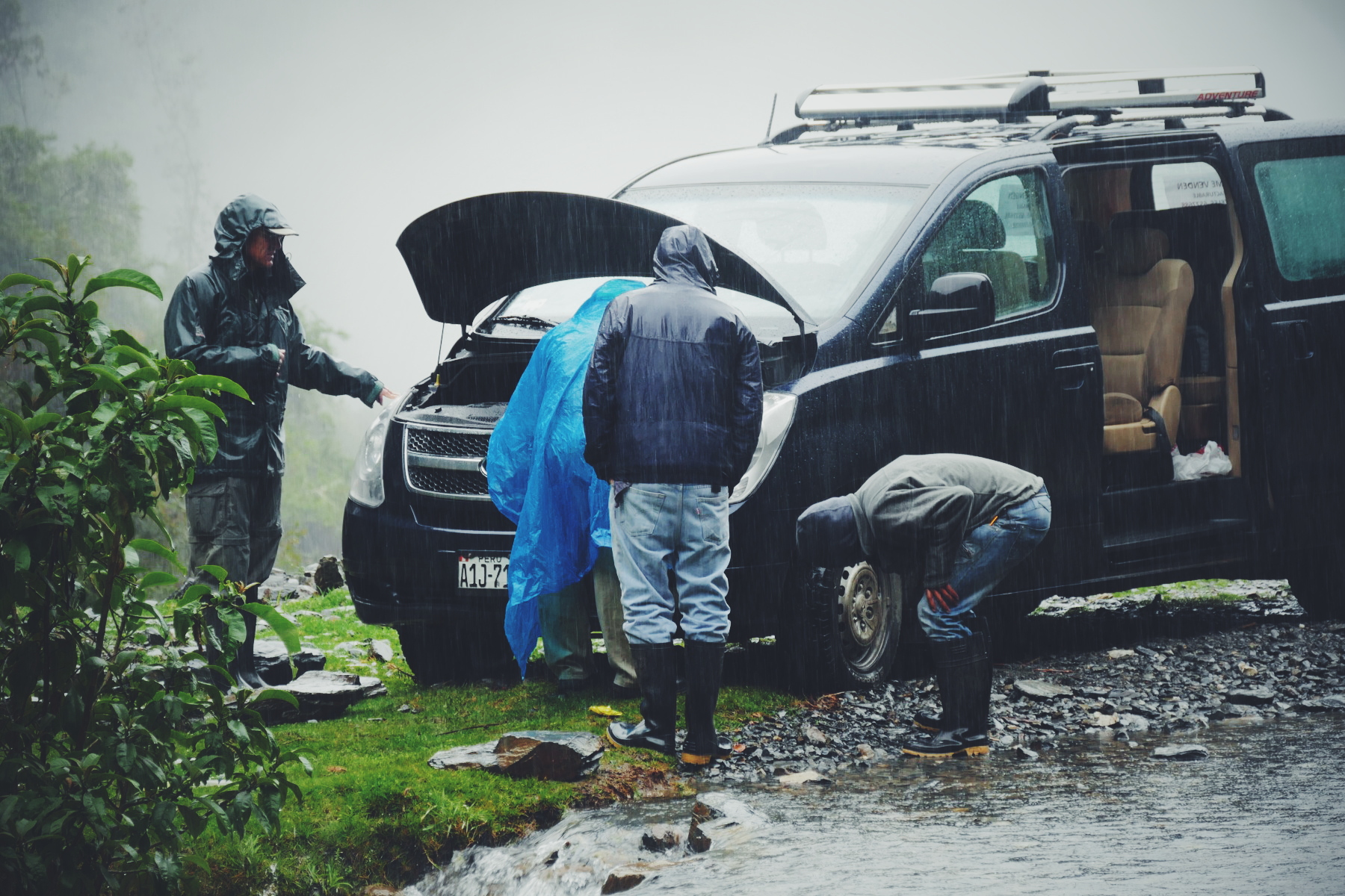 Changing the van's dead battery in a cold drizzle. Noah Strycker