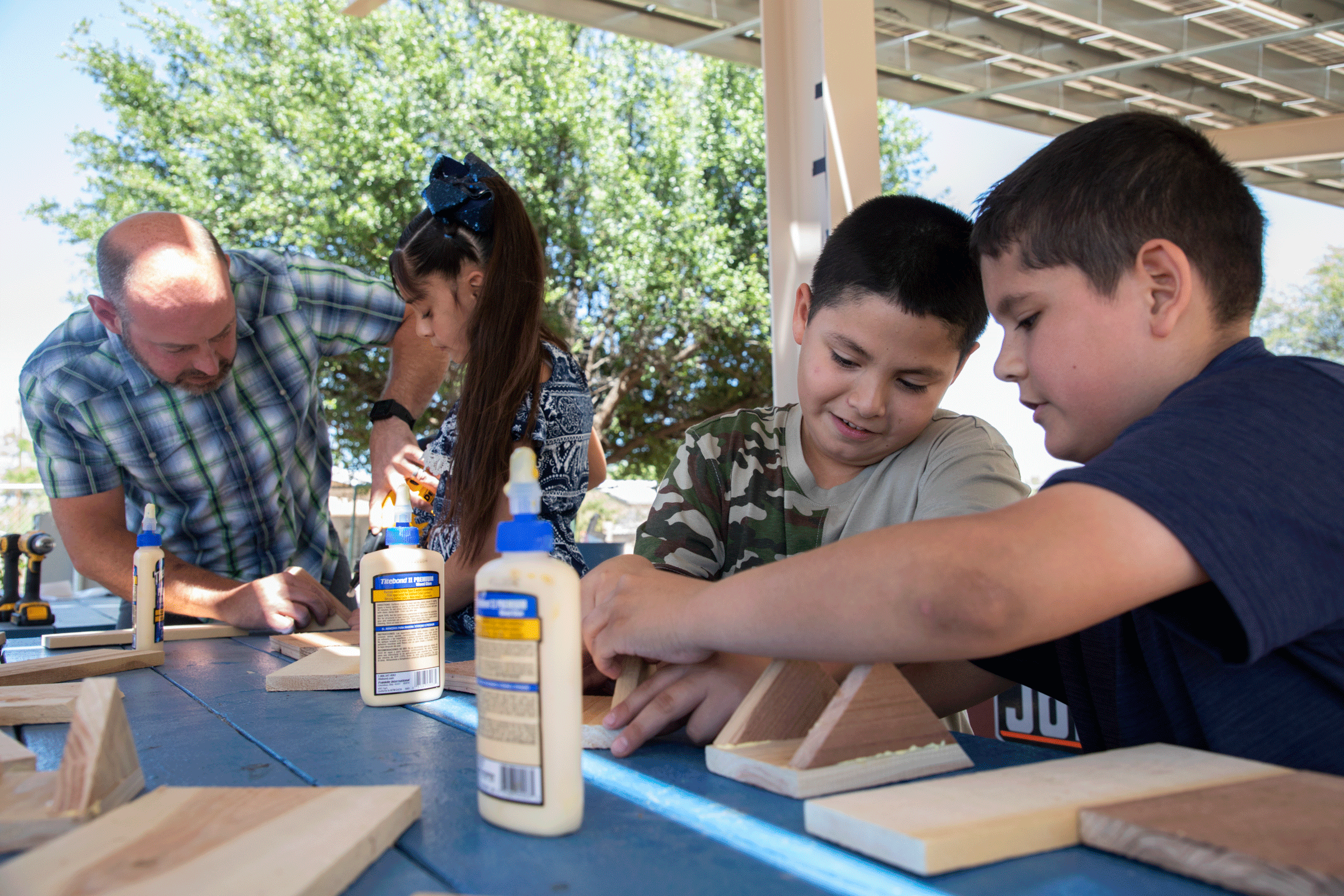 Jonathan Horst, a la izquierda, ayuda a los alumnos de cuarto grado de Manzo Elementary School en Tucson a construir nuevas cajas nido para chipes.