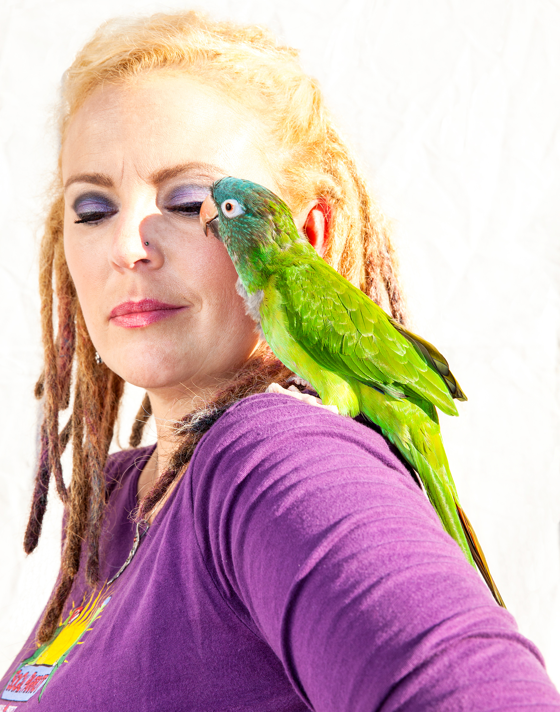 Since 2007 Durham (with a Blue-crowned Parakeet) has opened her home to parrots suffering from various injuries, including electrocution, pellet-gun wounds, and broken wings. Tom Fowlks