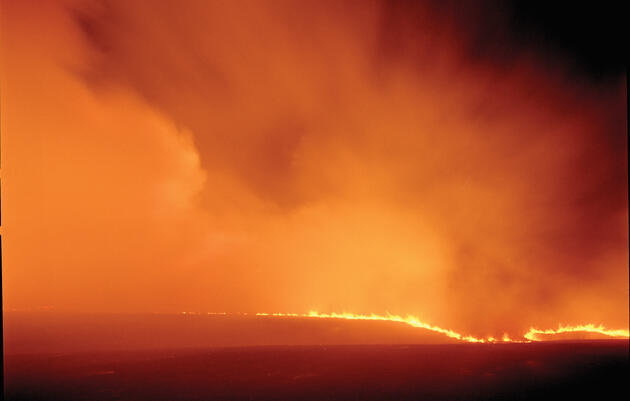 A wall of fire crests a hill along Bloody Creek Road in Chase County, Kansas. Larry Schwarm