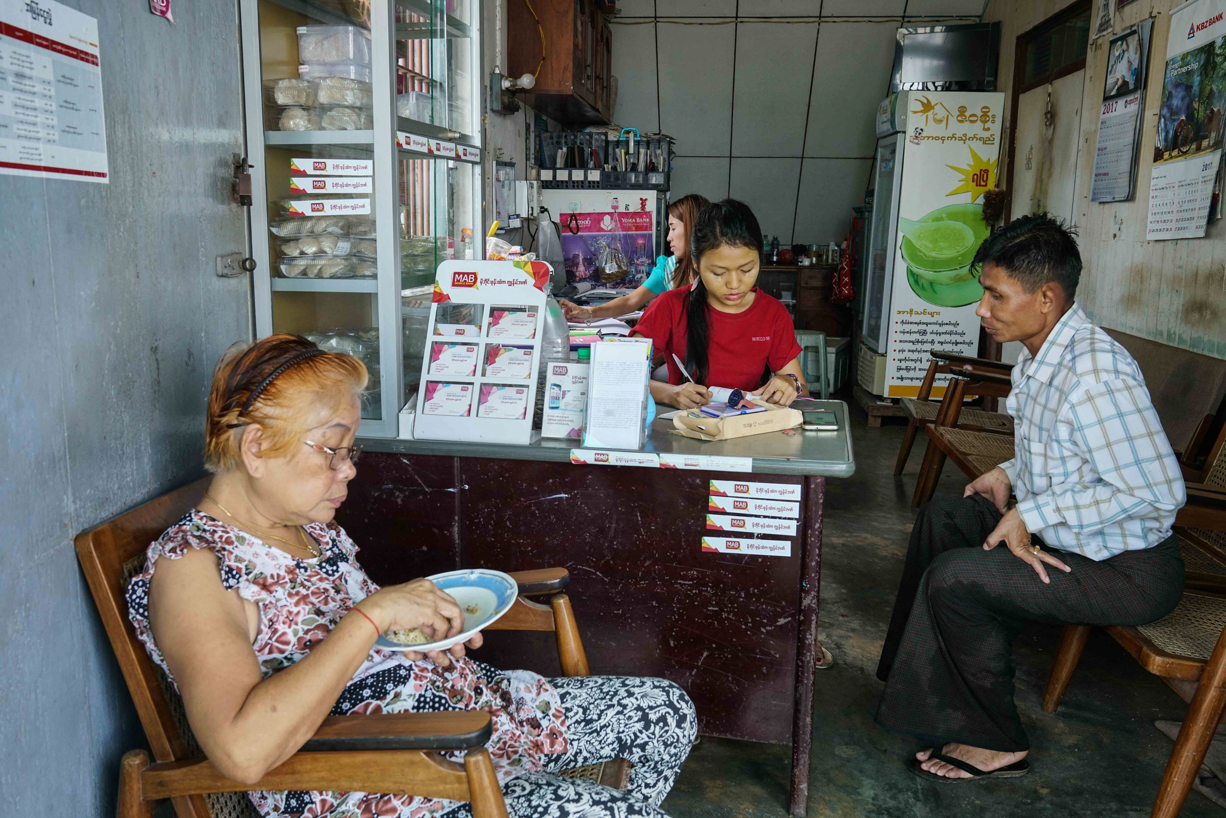A typical Myanmar house farm (like the one in the video above) has a nesting space on the top floor and a shop on the bottom. Here, owner Daw Myint Win (in the foreground) presides over a busy afternoon of business. Aung Naing Soe