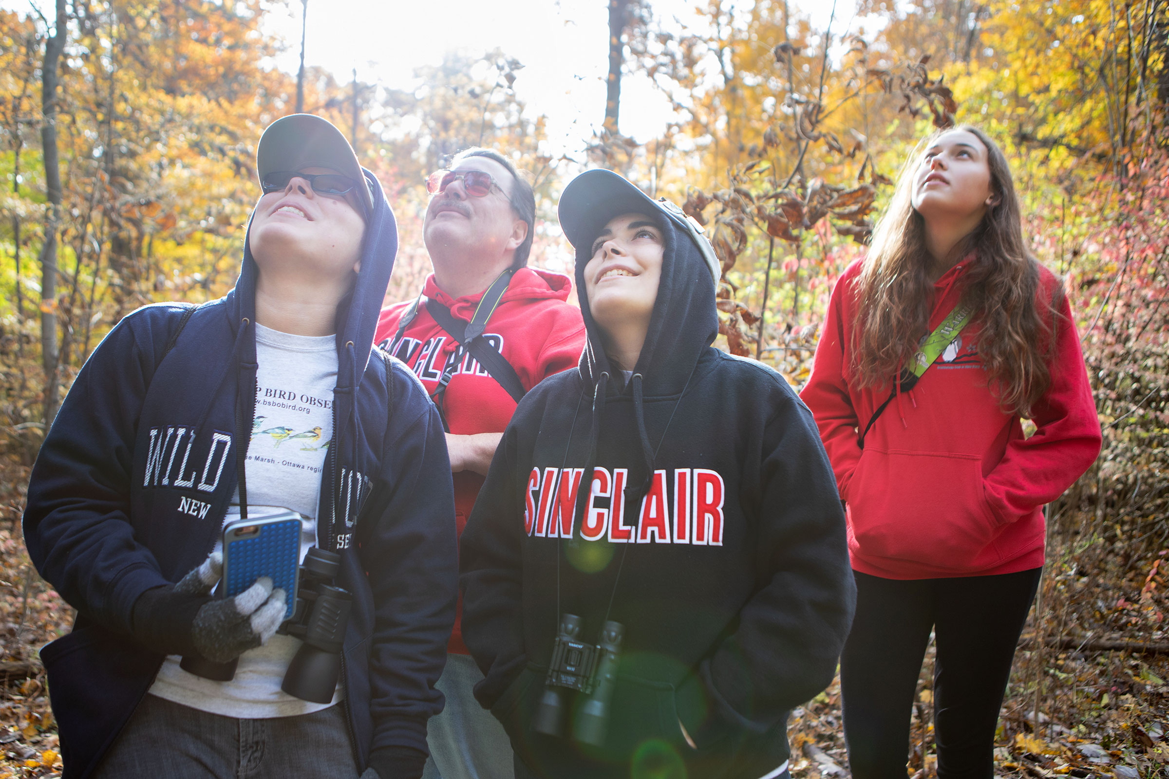 Young birders (from left) Christina Price and Danielle Price, along with their dad, join Cassidy Ficker on a field trip at the Blendon Woods in Columbus, Ohio. Camilla Cerea/Audubon
