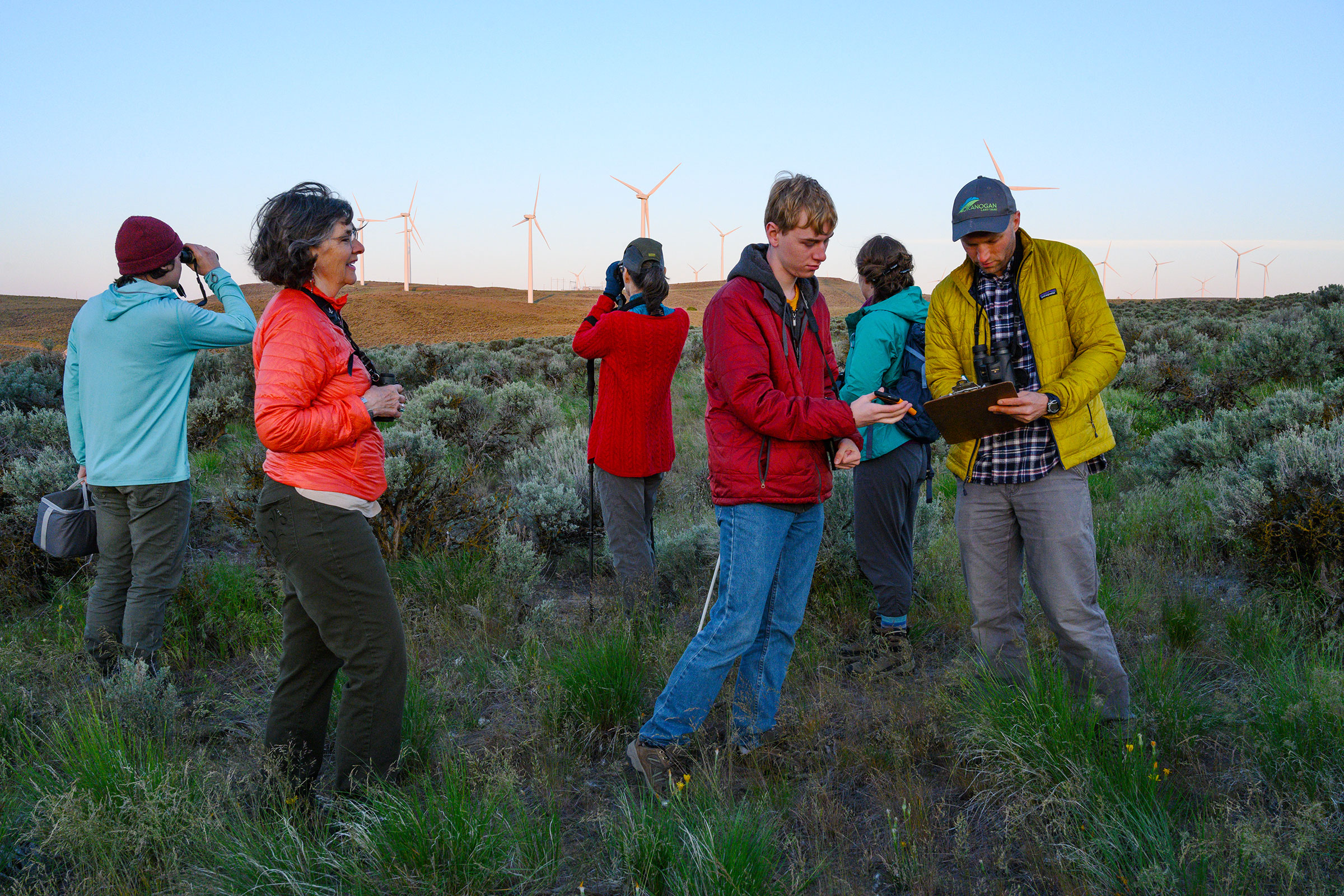 Un grupo del Relevamiento de aves cantoras llega a Wild Horse Wind & Solar Facility en el Condado de Kittitas, Washington, a primera hora. Al frente, Christi Norman observa cómo los voluntarios Curtis Mahon y John Rohrback registran datos.